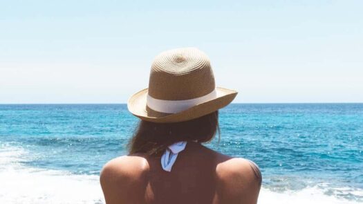 Woman wearing hat looking out at the water - Serendipity Anna Maria